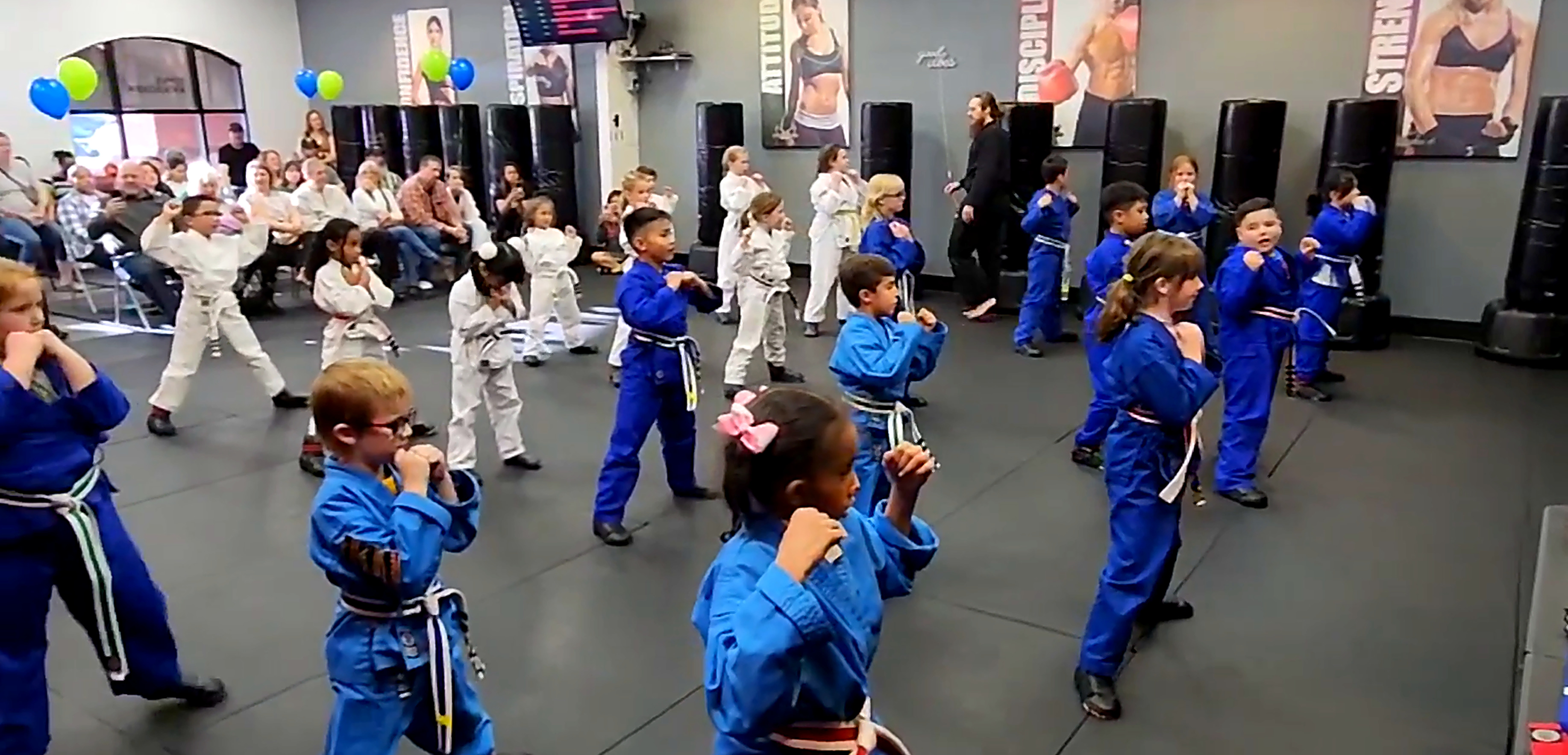 Full kids martial arts class in Las Vegas holding their fighting stance together on the mats